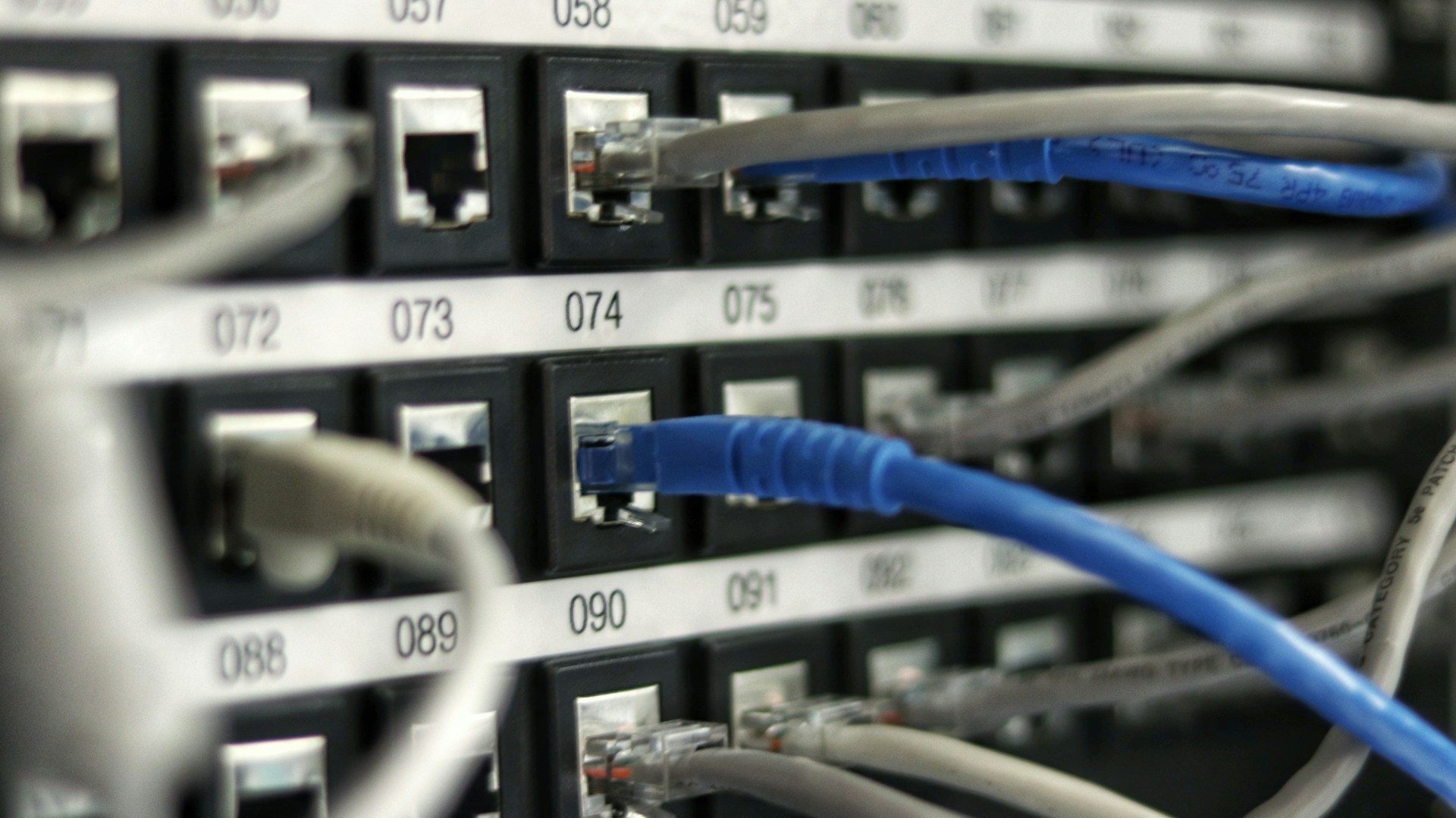 Technicien fibre optique raccordant des câbles dans une armoire réseau