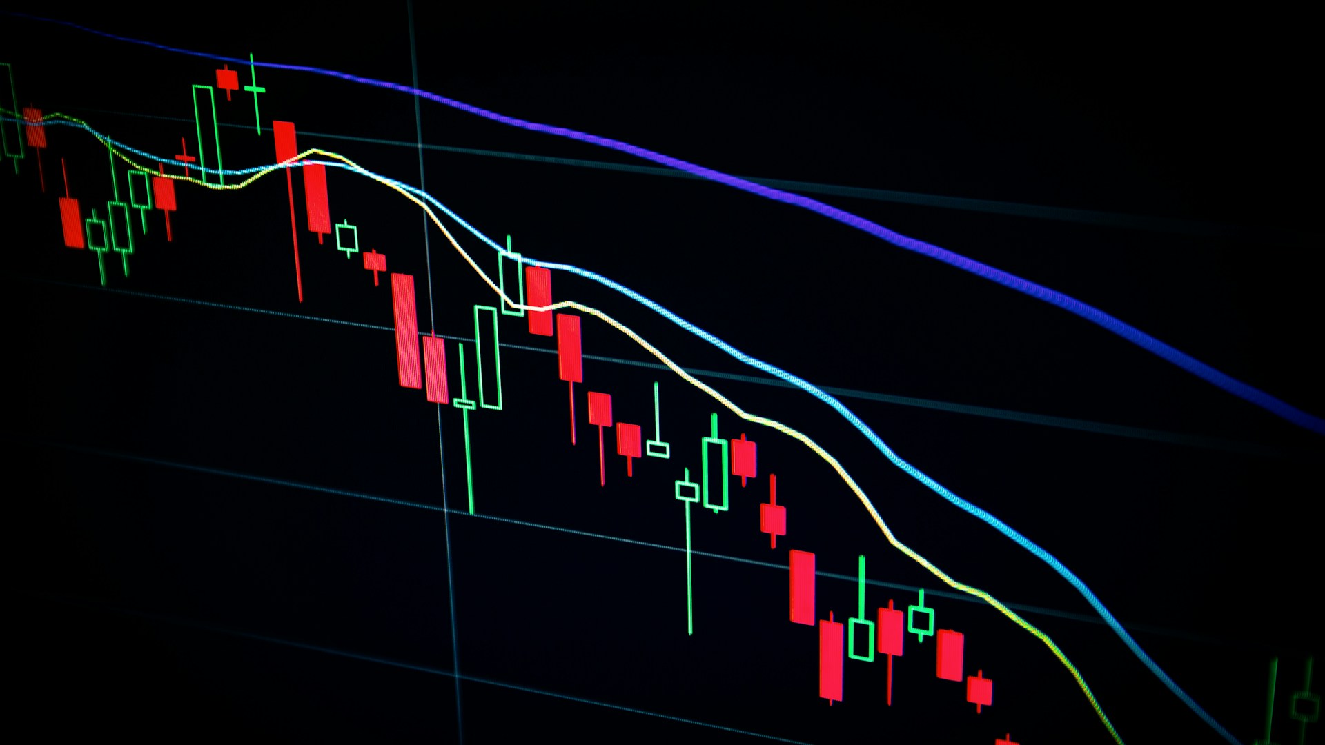 Trader analysant des graphiques financiers sur plusieurs écrans