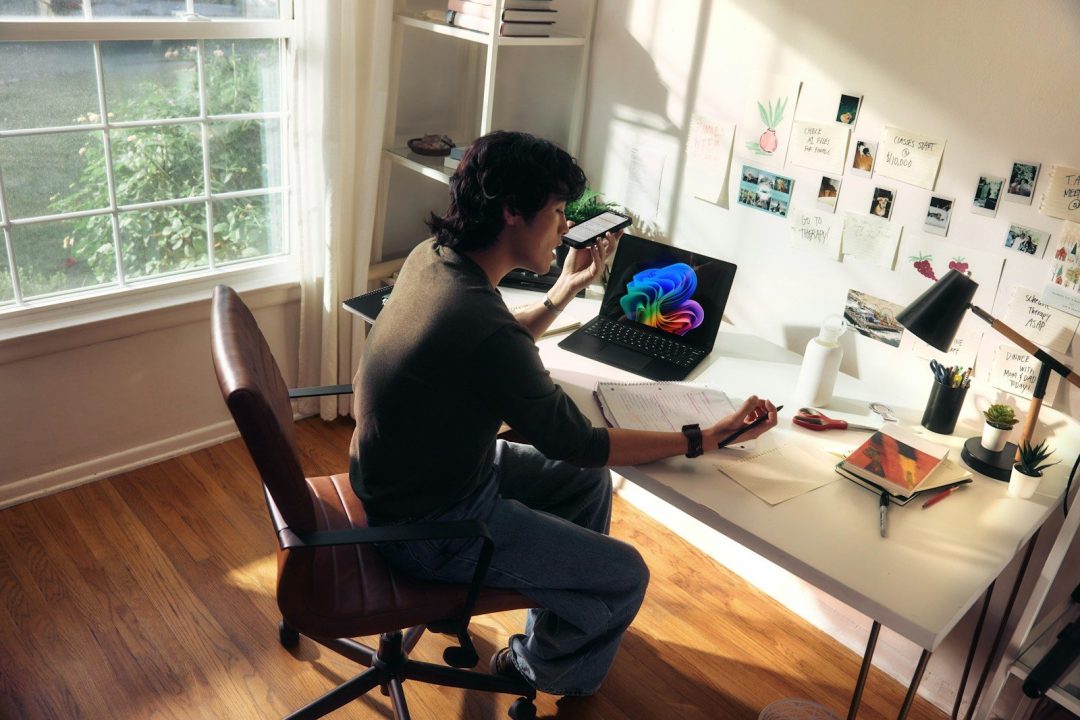 Person working at a desk with a laptop and books
